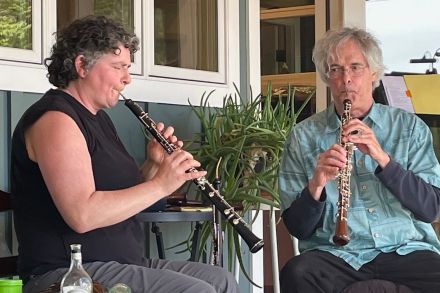 Three female musicians with violin and oboe tuning up before a classical performance.
